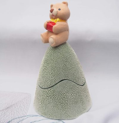 Ceramic trinket holder with a teddy bear on top.