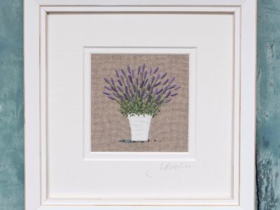 Hand embroidered white Lavender pot on beige linen background and framed is a white mount and frame