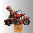 Ceramic sculpture of a figure on a red motorbike