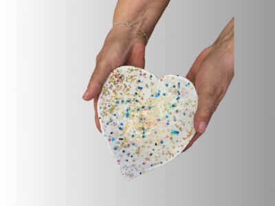 Unique heart-shaped ceramic dish with paper hearts and gemstone accents.